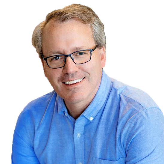Headshot of Ben, a white man with dark blonde hair and dark rimmed glasses. Ben is wearing a light blue dress shirt and is smiling towards the camera.