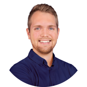 Headshot of Peter, a white man with brown hair and a trim beard. Peter is wearing a navy blue collared shirt and is smiling towards the camera.